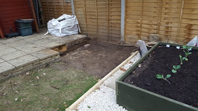 Cleared ground between the raised beds and main patio area