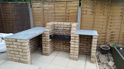 BBQ racks in place, supported on metal lugs, and worktops added to cupboards either side