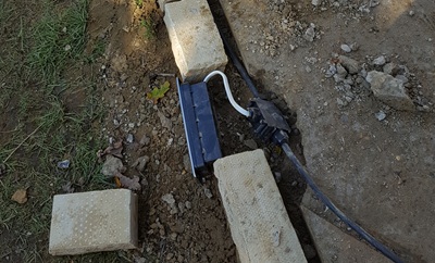 Lighting being installed to illuminate front wall of patio