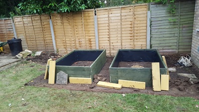 Edging being put in place between raised beds and lawn area