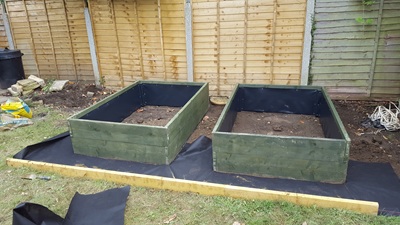 Edging between lawn and raised bed area now in place, weed resistant lining in progress