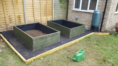 Weed resistant lining on area surrounding raised beds now completed